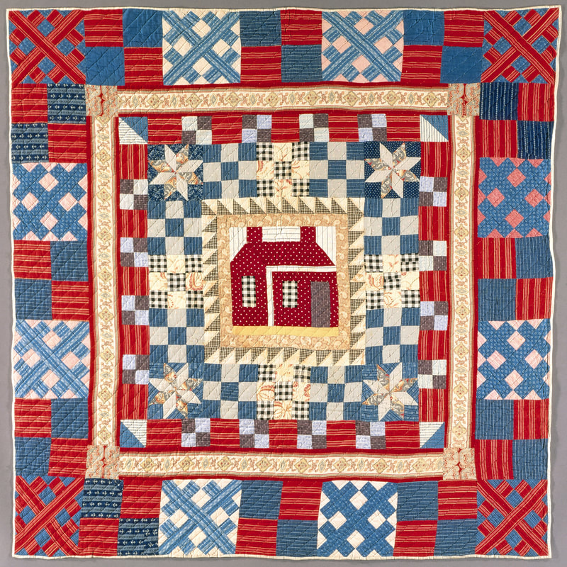 Red and blue checked quilt with framed red house in the center