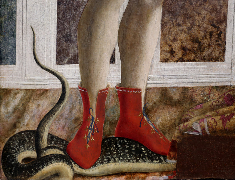 The feet of St. Michael in red shoes standing on a black snake