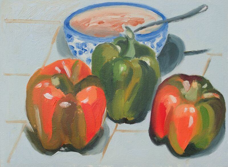 Three green and red bell peppers and a blue and white bowl of pink soup. 