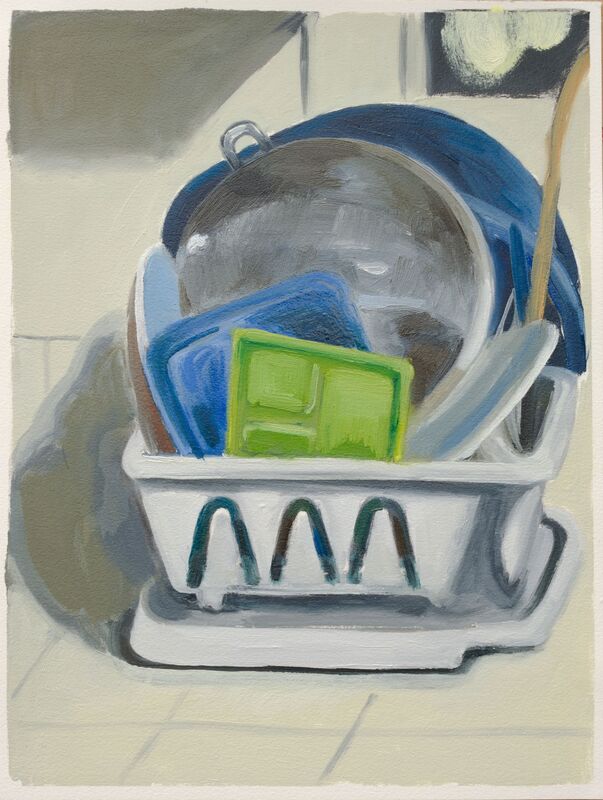 White dish drainer with blue and green dishes and a silver pot.