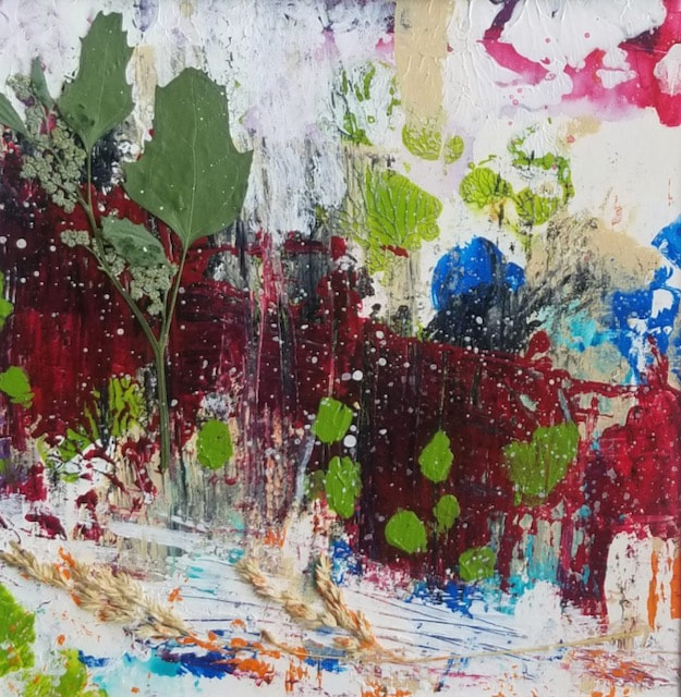 Abstract splattered paint in white, red, and blue with green spots and a leaf.